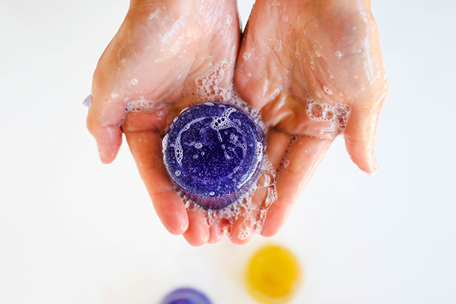 hands holding soapy purple disc