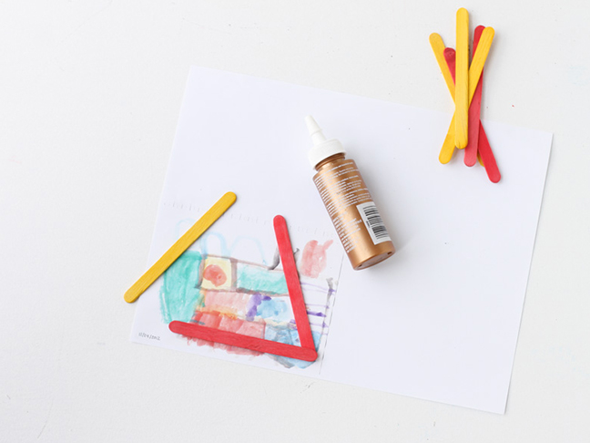 Add glue to popsicle sticks to create frame