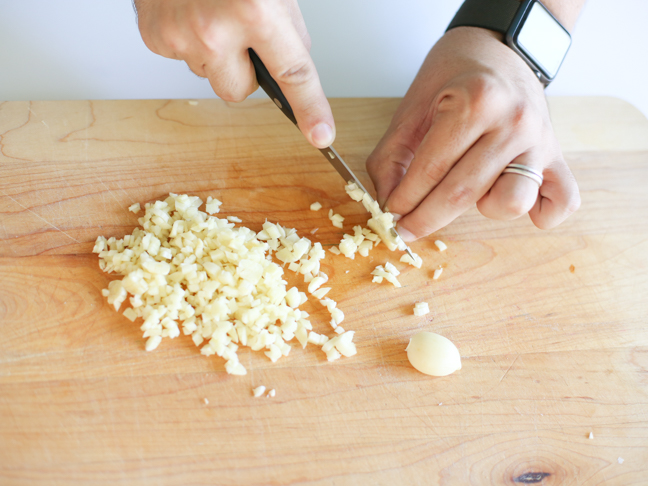 hands mincing garlic