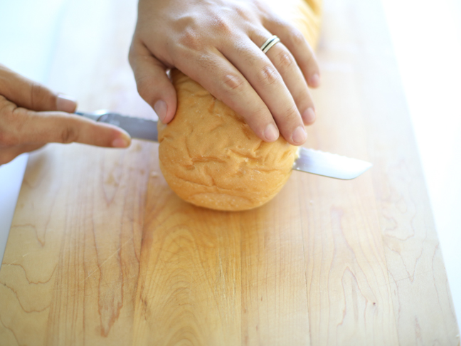 hands slicing french bread