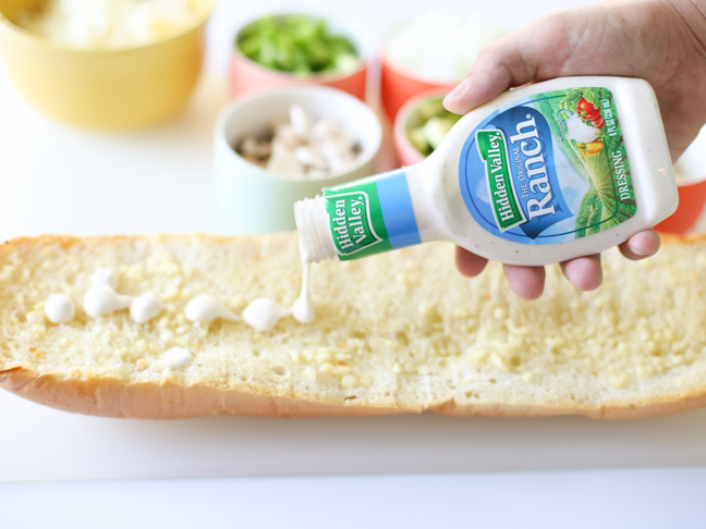 pouring ranch on garlic bread