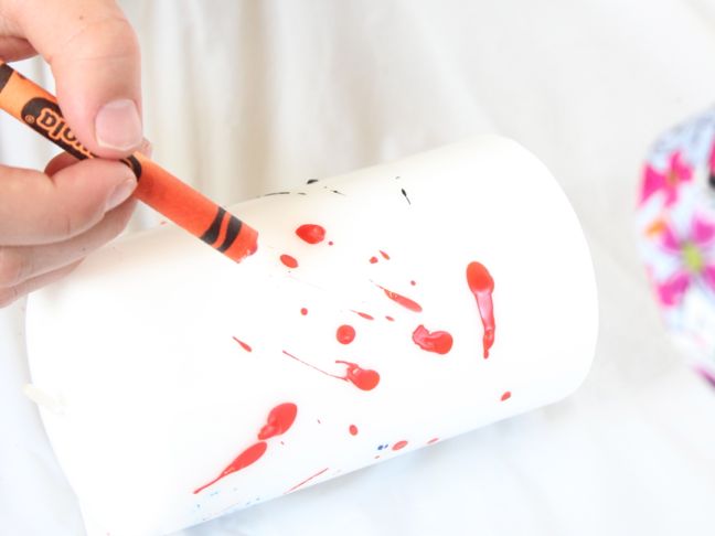 decorating candle with melted orange crayon