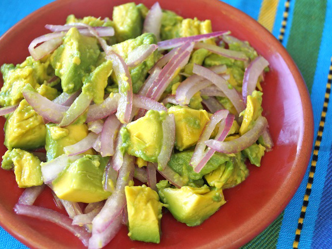 avocado-green-red plate-red onion slices-blue cloth