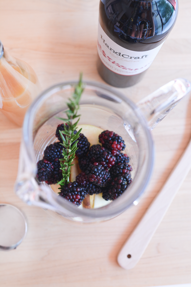 blackberries and rosemary sprig in glass pitcher