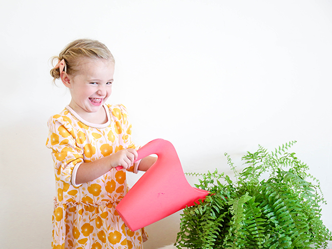 little girl watering a plant