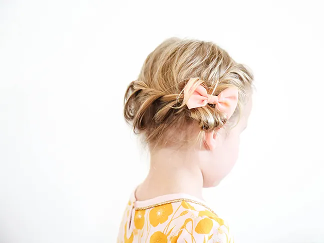 braided toddler hair with peach bow