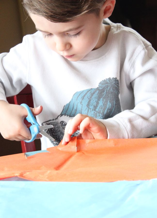 boy-cutting-tissue-orange-tissue-paper