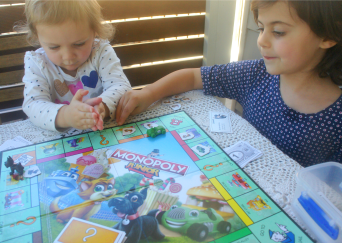 Siblings playing together on Monopoly Junior.