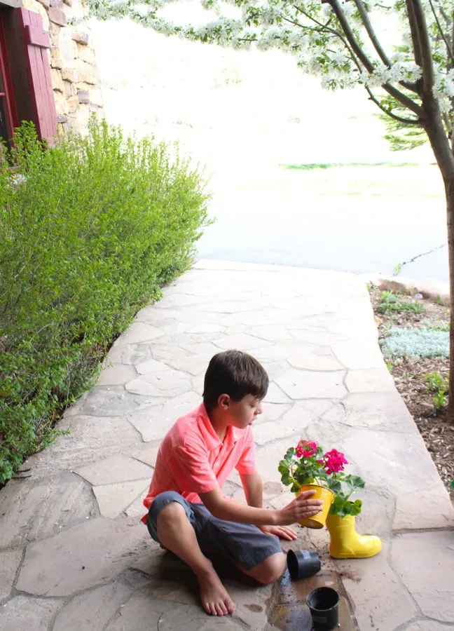 boy-planting-a-plant-inside-yellow-rain-boots