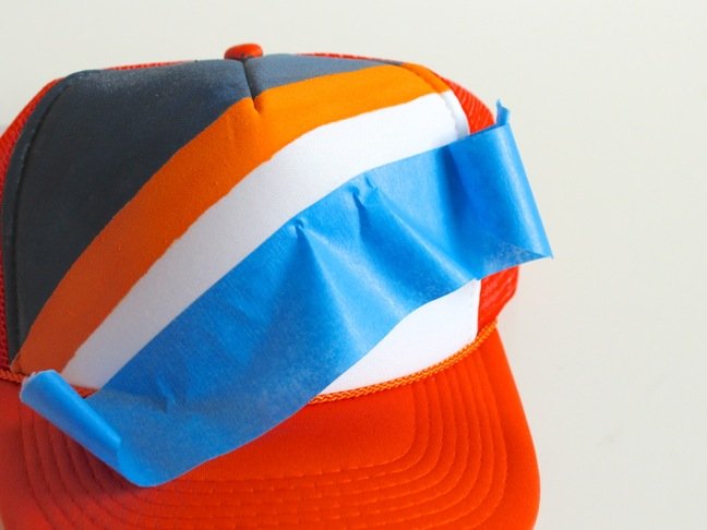 orange-and-blue-truckers-hat-with-blue-painters-tape
