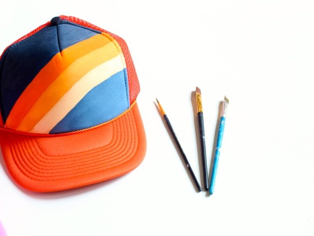trucker-hat-with-orange-and-blue-rainbow-and-paintbrushes