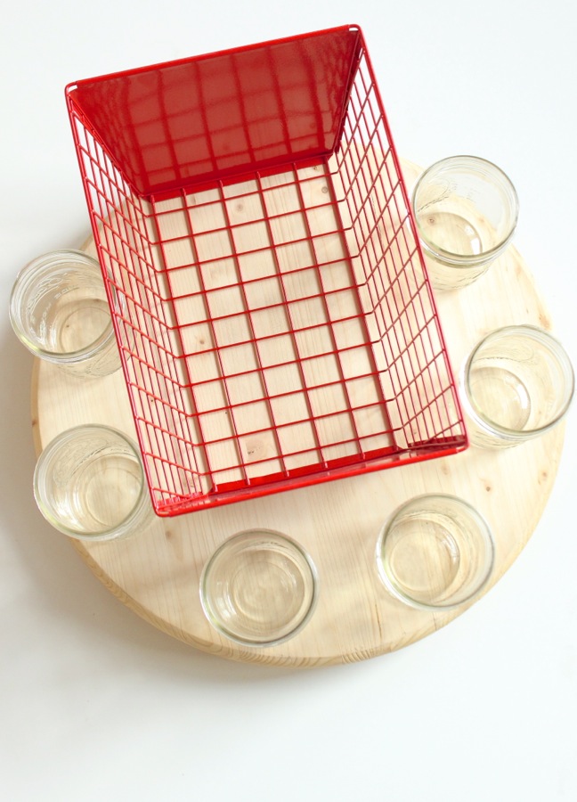 red-metal-basket-and-mason-jars-on-a-wood-round