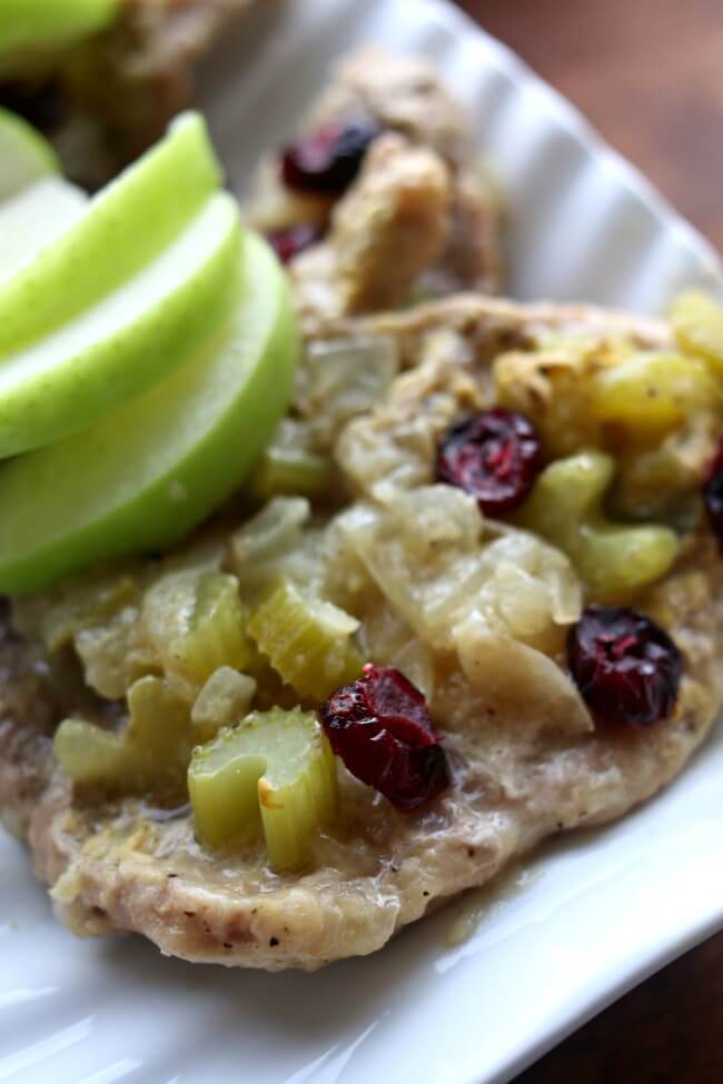 Slow Cooker Cranberry Apple Pork Chops--thin cut pork loin sirloin chops simmer with onion, celery, tart apple, apple juice and dijon mustard in the slow cooker and then are topped with dried cranberries to create a fresh seasonal flavored dish. 