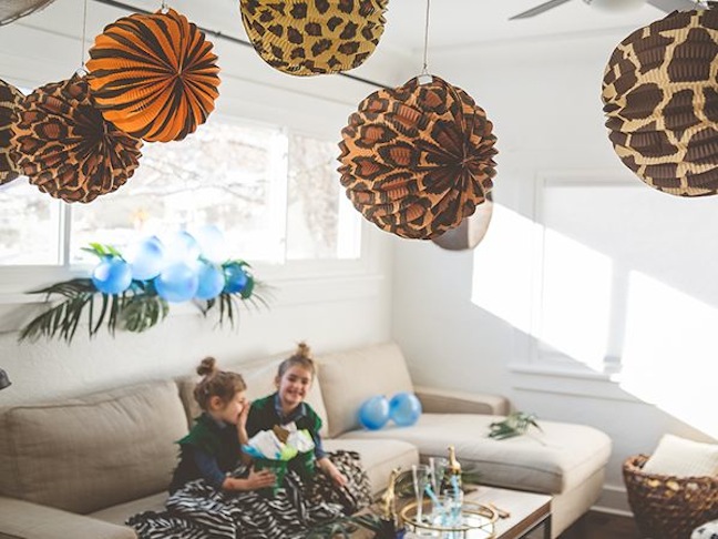 girls-hugging-with-leaf-vests-safari-blankets-jungle-party-hanging-lanterns