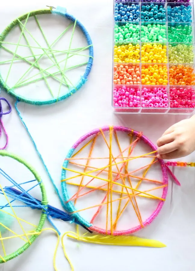 pink-yellow-blue-green-colorful-dream-catchers-childrens-craft-table-beads-feathers