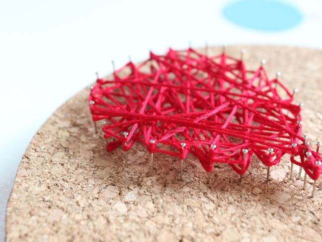 red-string-wrapped-around-pins-in-cork