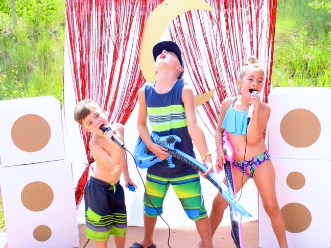 kids-in-swim-suits-singing-on-a-diy-mini-stage-with-microphones