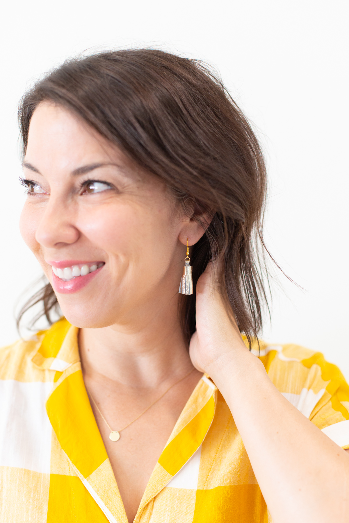 Woman wearing DIY gold tassel earrings