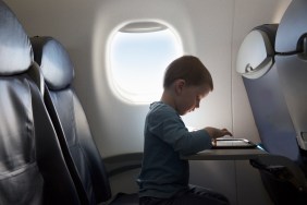 young boy using tablet on aeroplane
