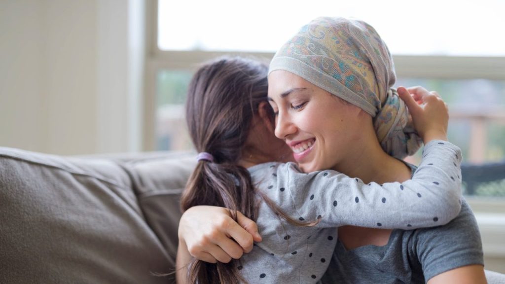Young mom with cancer hugging daughter post-mastectomy survival guide