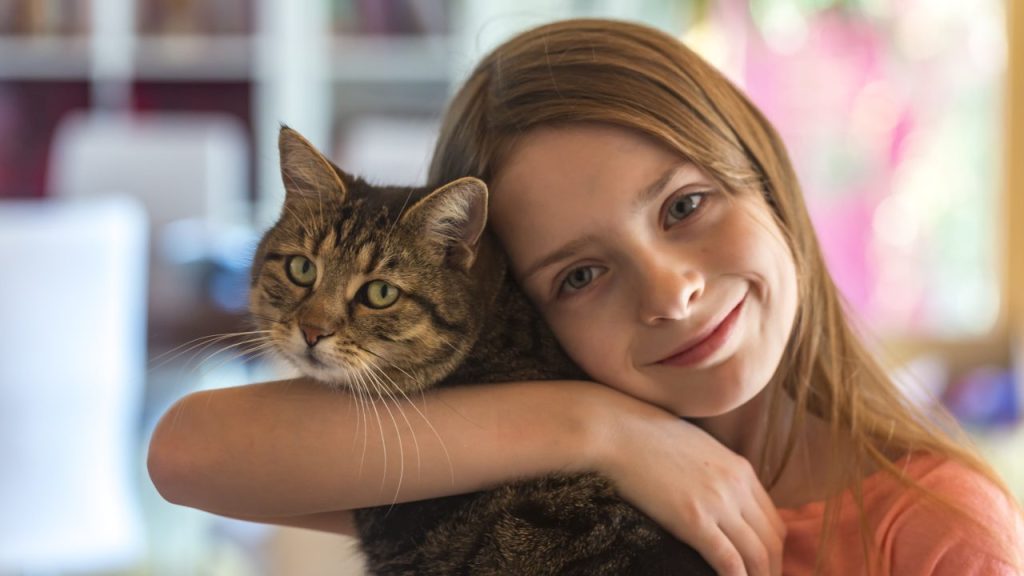 young girl hugs cat benefits of cat ownership for kids