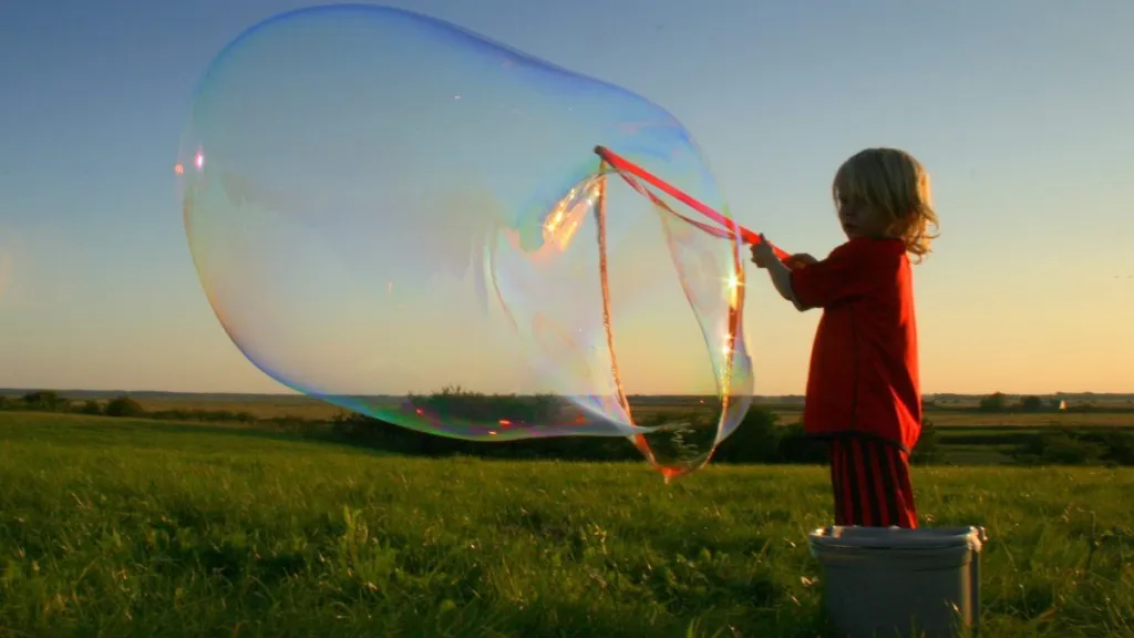 Young boy blows large soap bubble