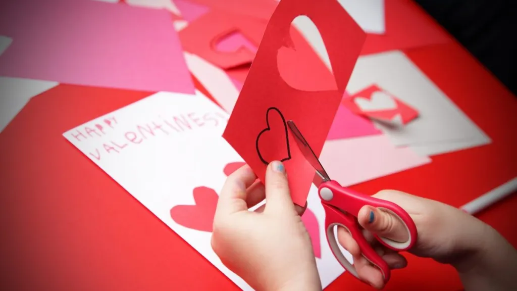 A girl makes the finishing touches to her "Happy Valentine's!" card.