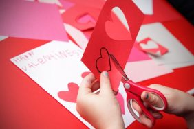 A girl makes the finishing touches to her "Happy Valentine's!" card.