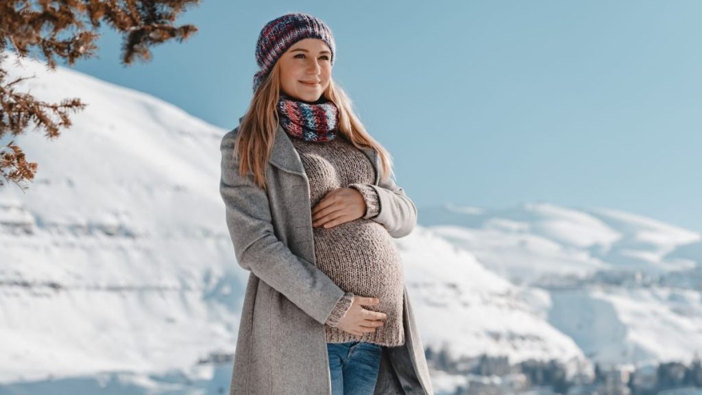 Pregnant Woman in Winter Clothes Touching her Belly