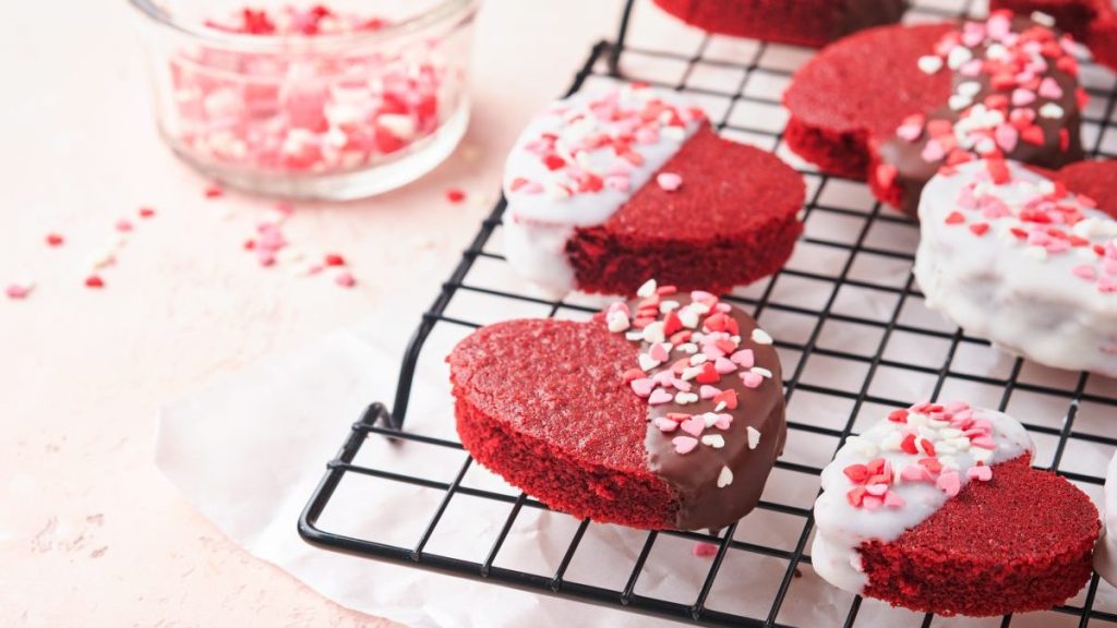 Red velvet or brownie cookies on heart shaped in chocolate icing on a pink romantic background. Dessert idea for Valentines Day, Mothers or Womens Day. Tasty homemade dessert. Cake for Valentines Day