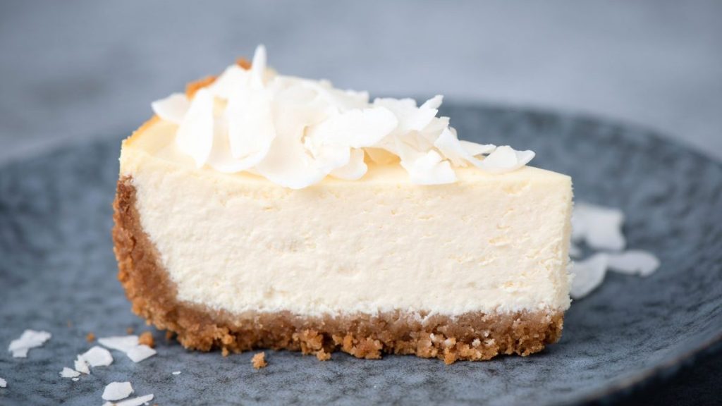 Slice of raw vegan coconut cheesecake on a plate. Coconut cashew cheesecake