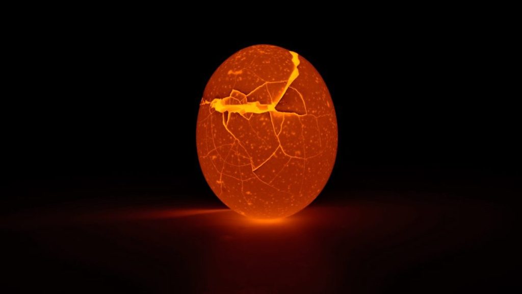 Cracked egg glowing orange light from within
