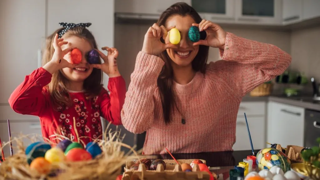 Happy girl having fun with mom and Easter eggs