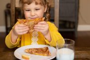 Young girl eating a grilled cheese sandwich.