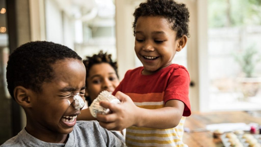 Young boys with cake frosting on faces at playdate