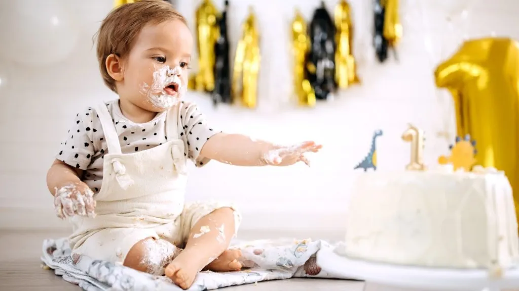 Cute little messy baby boy celebrating his first birthday