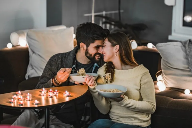 Young couple having a romantic dinner at home on Valentine's Day
