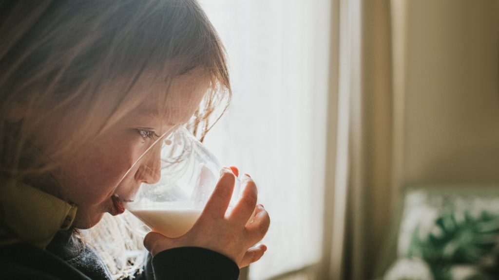 Cute preschool child drinking a glass of milk