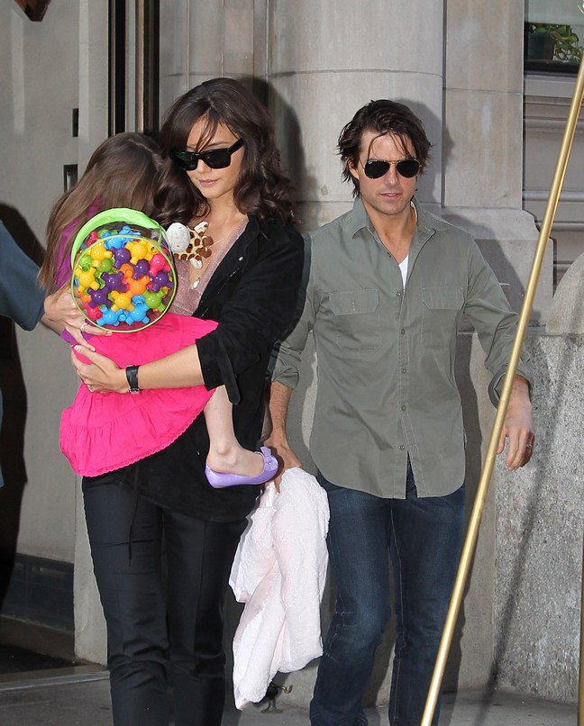 Tom Cruise, khaki shirt, sunglasses, jeans, Katie Holmes, black top, black pants, sunglasses, Suri Cruise, pink dress, colorful backpack